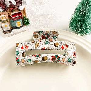 Détail d'une pince à cheveux de Noël avec motifs festifs sur assiette blanche