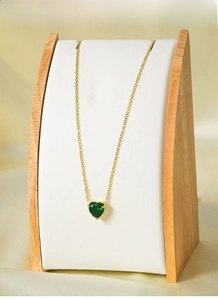 Detail view of heart-shaped green zircon pendant on 18k gold titanium steel necklace