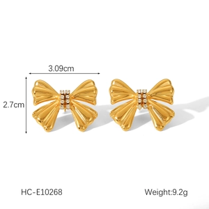 Detail of 18K gold bow earrings with crystal accents showing 3.09cm width dimensions