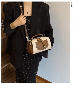 Détails d'un sac Boston bicolore crème et marron avec des finitions dorées chic
