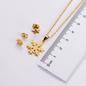 Größenmessung von goldenem Schneeflocken Halskette und Ohrring Set mit einem Lineal