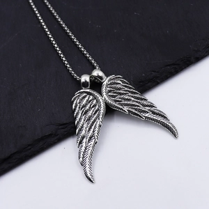 Vintage punk style double wing pendant necklace in distressed silver finish on dark stone