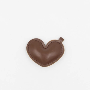 Close-up of brown PU leather heart charm with detailed stitching and small metal loop