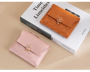 Detail of pink and caramel quilted PU leather wallets with gold flower snap button