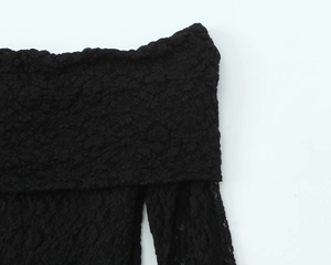 Détail de la dentelle noire et de l'encolure à épaules dénudées sur la robe
