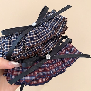 Detail of plaid fabric scrunchies with black bows and floral crystal charms