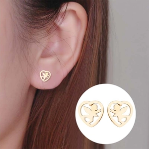 Boucles d'oreilles cœur doré avec silhouette d'ange portées par un mannequin en détail