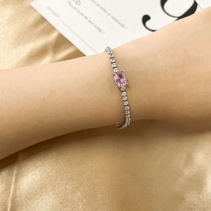 Elegant silver bracelet with pink oval gemstone and sparkling zircon accents on gold silk