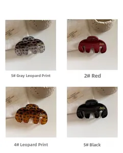 Detailset van vier hars haarklemmen in grijs, rood, bruin en zwart met luipaardprint