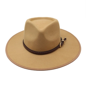 Detail of camel wool fedora with dark brown braided leather band and gold buckle