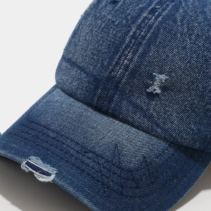Distressed dark blue denim baseball cap with vintage embroidery and torn details