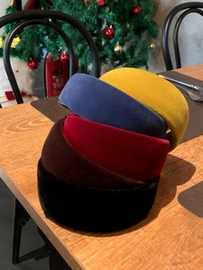 Pile of padded velvet headbands in yellow, blue, red and black colors with soft texture