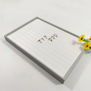 Grey jewelry display tray with 100 slots for golden rings and stud earrings storage