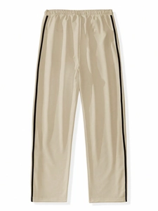 Detail of off-white casual pants featuring black side stripes and elastic waist design