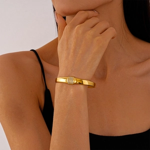 Detail of gold-plated geometric bracelet featuring a rectangular paved diamond centerpiece