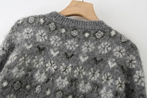 Macro shot of grey jacquard knit sweater featuring fluffy texture and floral snowflake pattern