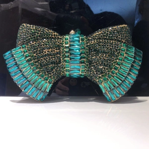 Detailed close-up of bow-shaped clutch bag with gradient green crystal rhinestones