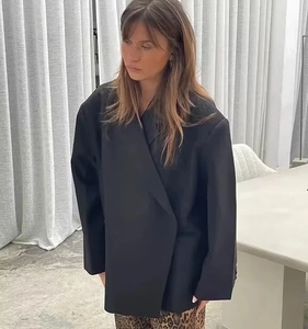 Détail d'un blazer noir surdimensionné avec col à revers et design minimaliste et ample