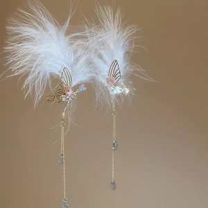 Detail of silver needle earrings with white feathers, pink crystals and gold tassels