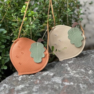 Detailed close-up of cute acorn-shaped crossbody bags for kids in orange and beige colors