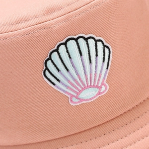 Detail of shell embroidery and cotton canvas stitching on a pink sun bucket hat