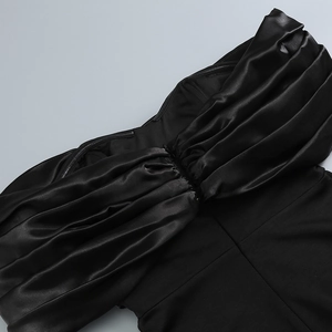 Detail of elegant black pleated satin neckline on a shoulderless evening dress