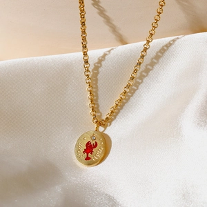 Macro detallada del colgante de langosta en oro 18k con esmalte rojo sobre seda blanca