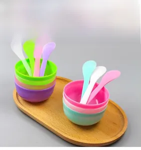 Macro view of colorful plastic mixing bowls and spatulas set for facial mask preparation