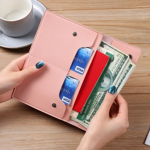 Pink minimalist multi-slot passport wallet and phone bag held open on wooden table