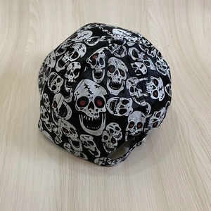 Detail of adjustable metal buckle and red-eyed skull print on black baseball cap