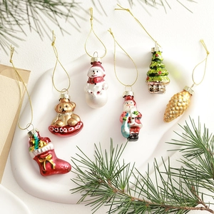 Vintage Christmas ornaments set with glass motifs on a white tray with pine needles