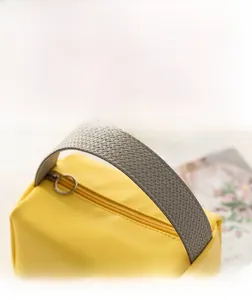 Detailansicht von gewebtem Griff und Metallreißverschluss an gelber Kulturtasche