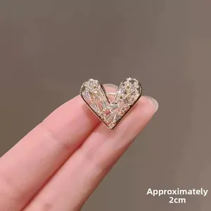 Detailed view of 2cm heart-shaped brooch with sparkling cubic zirconia on gold base