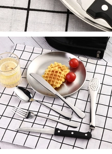 Detail of stainless steel cutlery set with steak knife and fork on a checkered mat