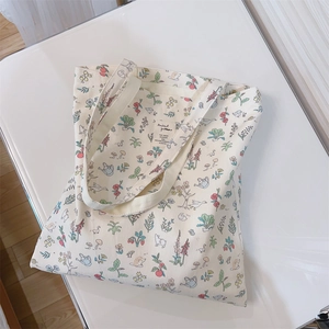 Detail of floral canvas tote bag featuring hand-drawn animal and flower prints