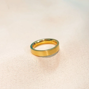 Close-up of a matte 18k gold plated titanium steel ring on textured fabric surface