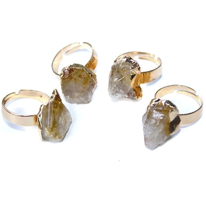Macro detail of set of four gold adjustable rings with irregular natural citrine stones