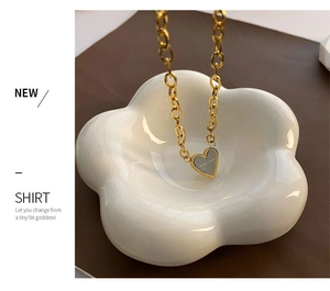 Detail of gold heart pendant with Never Forget engraving on chunky link chain