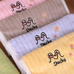 Macro detail of soft absorbent hanging towels with colorful duck embroidery for kids