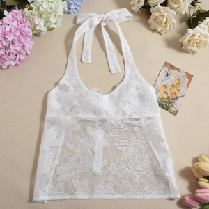 Close-up of white lace halter top featuring floral mesh texture and tie neck detail