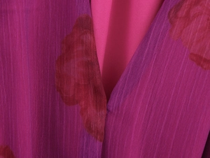 Détail du col en V sur robe en mousseline fleurie bordeaux avec texture plissée