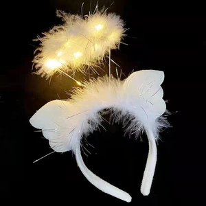 Detail of white feather halo headband with glowing LED lights against dark background
