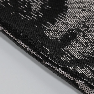 Macro shot of high-density black and silver sequins with reflective fabric texture