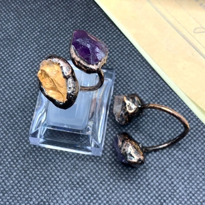 Detail of vintage adjustable rings featuring natural amethyst and citrine stones in bronze