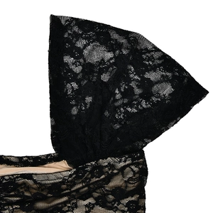 Détail de dentelle noire sur doublure beige avec motifs floraux sur le haut sexy