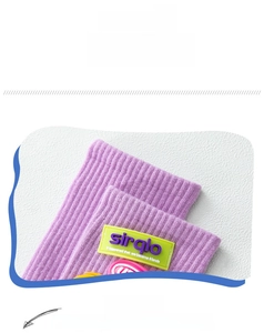 Close-up of purple ribbed cotton socks with a green silicone label and elastic cuff