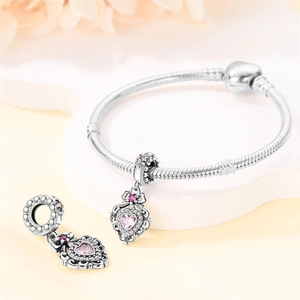 Close-up of silver beaded bracelet featuring a pink heart-shaped crystal pendant