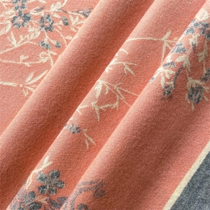 Gros plan détaillé d'une écharpe douce avec motifs floraux et franges élégantes