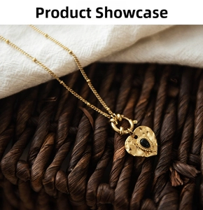 Detail of 18K gold plated heart pendant with hammered texture and black stone