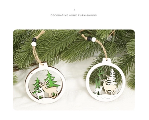 Detail of wooden Christmas tree ornaments with reindeer carving and pine leaf background
